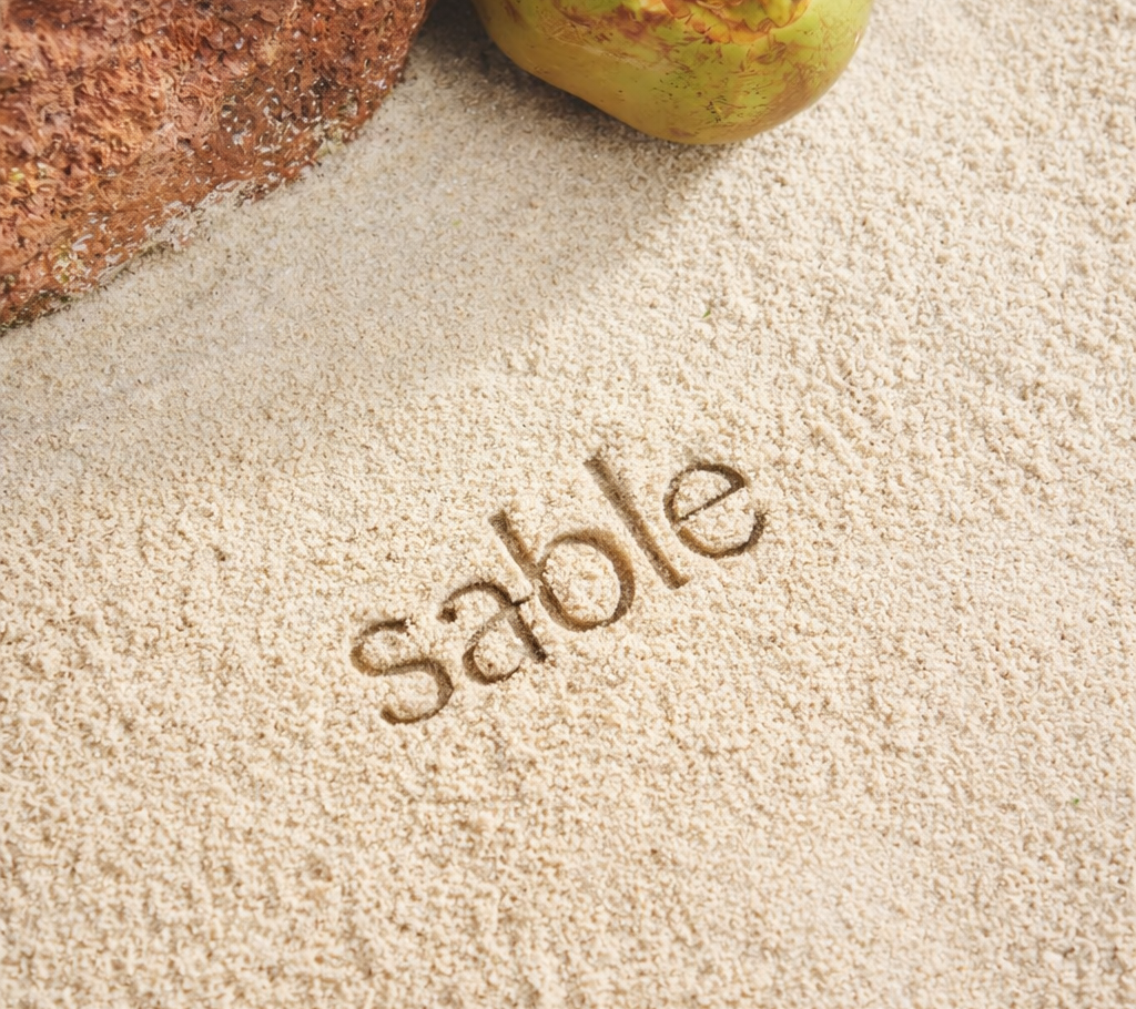 Coconut on sand with 'sable' branding